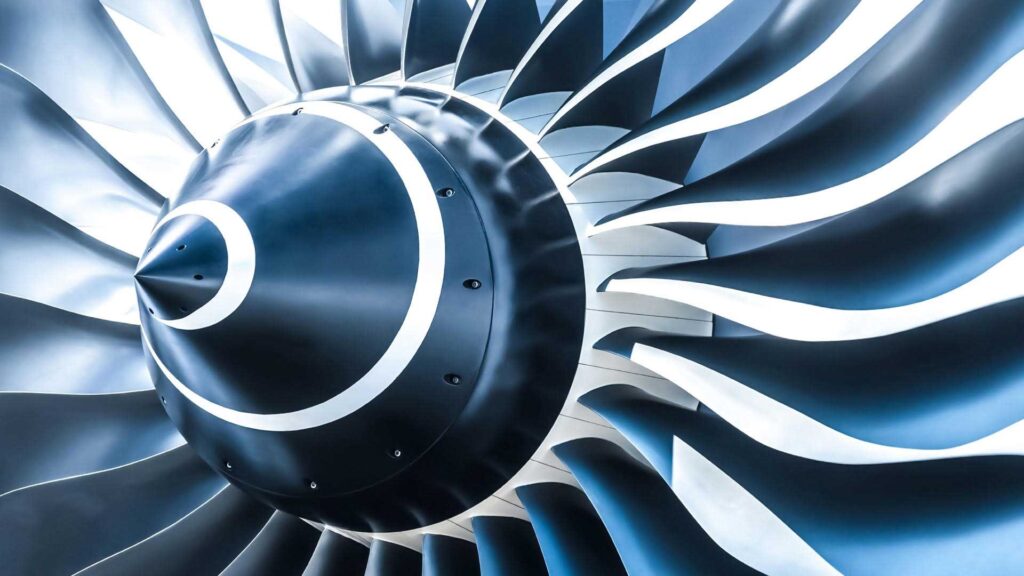 Close-up of a jet engine turbine with metallic blades, showcasing advanced engineering and precision manufacturing.