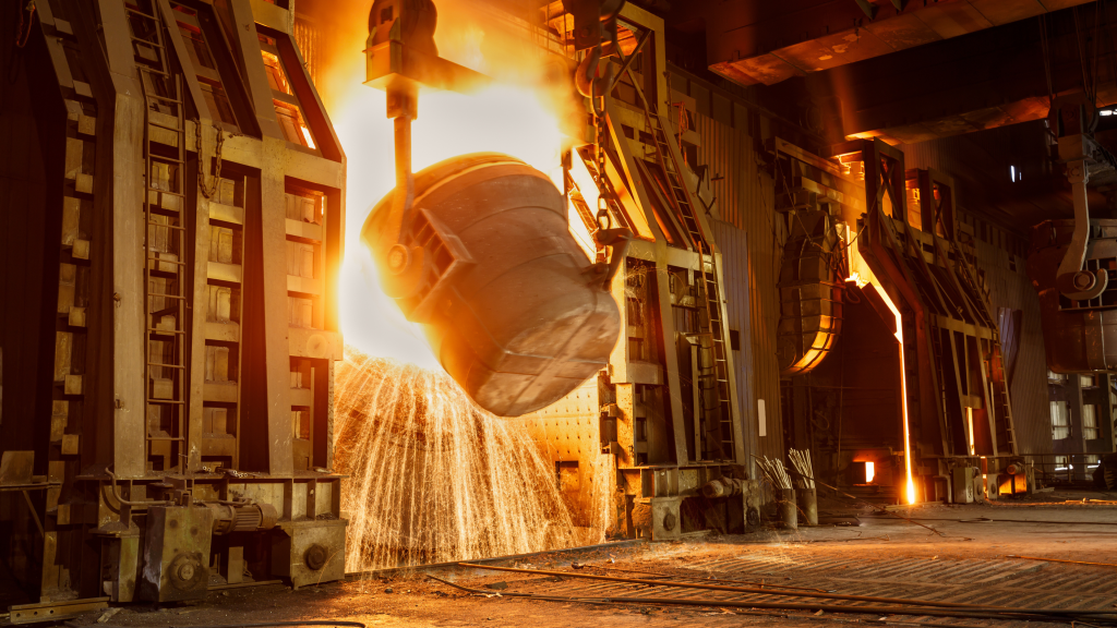 Molten steel being poured from a ladle in an AOD-BOF process at a steel plant.