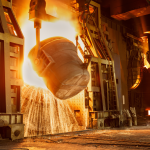 Molten steel being poured from a ladle in an AOD-BOF process at a steel plant.